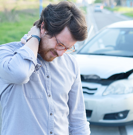 A man holds his neck after car crash